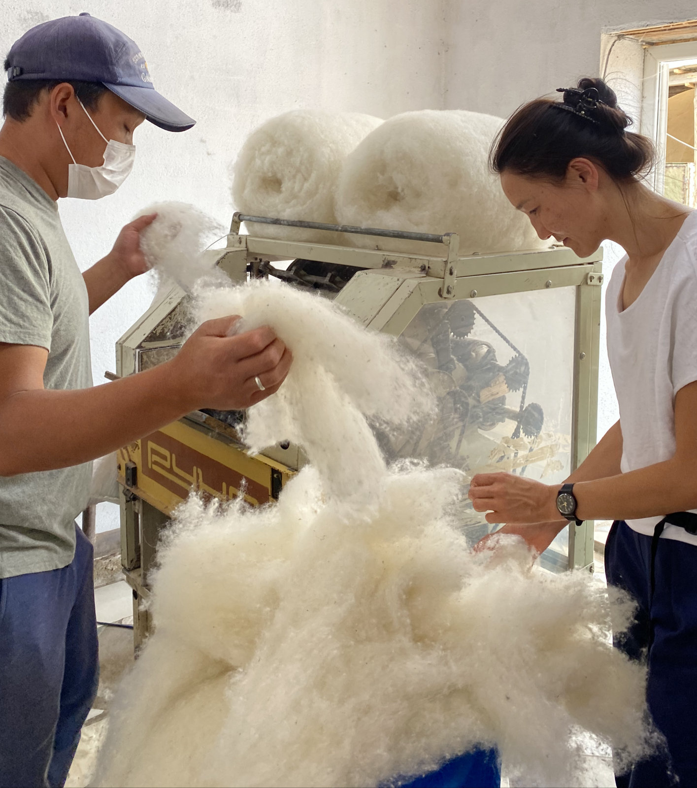 Carding raw wool together at the machine